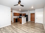 Thumbnail 48 of 56 - A room with a kitchen island and wooden floors at Meadowlark Place Apartments, Grimes, Iowa