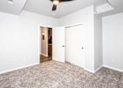 Thumbnail 51 of 56 - A room with a carpeted floor and a ceiling fan at Meadowlark Place Apartments, Grimes, IA