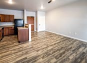 Thumbnail 37 of 56 - A room with wooden flooring and a kitchen area with cabinets and a counter at Meadowlark Place Apartments, Georgia