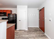 Thumbnail 25 of 56 - A kitchen with a black fridge and wooden cabinets at Meadowlark Place Apartments, Grimes, Iowa