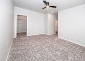Thumbnail 15 of 56 - A room with a ceiling fan and carpeted floor at Meadowlark Place Apartments, Grimes, IA,  50111