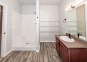 Thumbnail 13 of 56 - A bathroom with a white tub and wooden floors at Meadowlark Place Apartments, Grimes