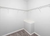 Thumbnail 16 of 56 - A white closet with a carpeted floor and a white bench at Meadowlark Place Apartments, Grimes, IA,  50111