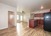 Thumbnail 8 of 56 - A kitchen with wooden floors and a black refrigerator at Meadowlark Place Apartments, Iowa, 50111