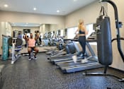 Thumbnail 55 of 56 - A man and a woman are working out in a gym at Meadowlark Place Apartments, Iowa, 50111