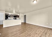 Thumbnail 46 of 47 - A large open living room with wooden flooring and a kitchen area in the background at Melbourne Apartments in Des Moines, Iowa 50320.