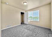 Thumbnail 47 of 47 - A room with a carpeted floor and a window with blinds.