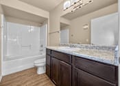 Thumbnail 8 of 47 - A bathroom with a toilet, sink, and shower at Melbourne Apartments in Des Moines, Iowa 50320.