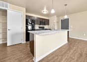 Thumbnail 6 of 47 - A kitchen with a pantry closet and a island counter at Melbourne Apartments in Des Moines, Iowa 50320.