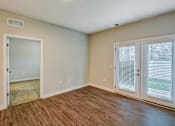 Thumbnail 10 of 12 - A room with a wooden floor and a sliding glass door.
