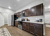 Thumbnail 14 of 69 - a kitchen with dark wood cabinets and a stainless steel refrigerator at Converge NW, Iowa  