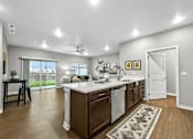 Thumbnail 12 of 69 - a kitchen with an island and a door to a living room at Converge NW, Waukee, IA  