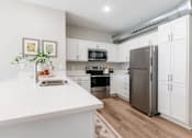 Thumbnail 40 of 69 - A kitchen with white cabinets and a stainless steel refrigerator.at Converge NW, Waukee, IA 50263  