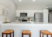Thumbnail 41 of 69 - a kitchen with a counter top and stools at Converge NW, Waukee, IA  