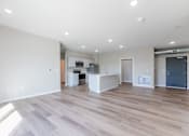 Thumbnail 6 of 69 - the living room and kitchen of a new home with white walls and wood flooring at Converge NW, Waukee, 50263  