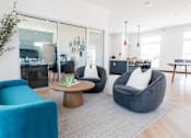 Thumbnail 55 of 69 - a living room with blue chairs and a table at Converge NW, Waukee, IA 50263  