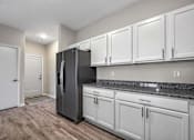 Thumbnail 22 of 42 - a kitchen with white cabinets and a black refrigerator at Forge65, Iowa, 50327