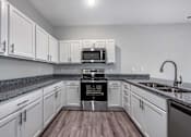 Thumbnail 19 of 42 - a kitchen with white cabinets and a sink and a stove at Forge65, Pleasant Hill, 50327