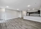 Thumbnail 2 of 42 - the living room and kitchen of a new home with white walls and wood flooring at Forge65, Pleasant Hill, 50327