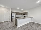 Thumbnail 9 of 42 - a kitchen with a counter top and a refrigerator at Forge65, Pleasant Hill, 50327