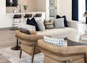 Thumbnail 4 of 42 - a living room with a couch and chairs and a kitchen at Forge65, Pleasant Hill, IA, 50327