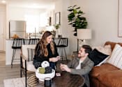 Thumbnail 11 of 42 - a man and woman sitting on a couch in a living room at Forge65, Pleasant Hill, 50327