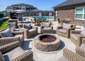 Thumbnail 32 of 50 - A patio with a fire pit and chairs. at Stonegate Crossing Apartments, Clive