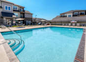 Thumbnail 27 of 50 - A swimming pool surrounded by a wooden deck and a fence. at Stonegate Crossing Apartments, IOWA