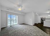Thumbnail 10 of 50 - an empty living room with a ceiling fan and a window at Stonegate Crossing Apartments, Clive, IOWA
