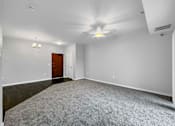 Thumbnail 5 of 50 - A room with a carpeted floor and a ceiling fan. at Stonegate Crossing Apartments, IOWA