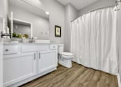 Thumbnail 21 of 57 - a bathroom with a shower curtain and a toilet at Rialto Townhomes Apartments, Waukee, IA, 50263