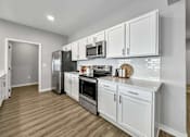 Thumbnail 10 of 57 - a kitchen with white cabinets and stainless steel appliances at Rialto Townhomes Apartments, Waukee, Iowa