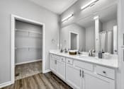 Thumbnail 11 of 57 - a bathroom with a large mirror and two sinks at Rialto Townhomes Apartments, Waukee, 50263