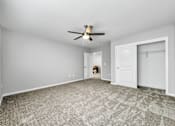 Thumbnail 24 of 57 - an empty living room with a ceiling fan and a closet at Rialto Townhomes Apartments, Waukee, Iowa
