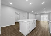 Thumbnail 32 of 57 - a white kitchen with a large island in the middle of it at Rialto Townhomes Apartments, Iowa
