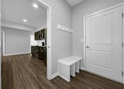 Thumbnail 29 of 57 - a door opens into a kitchen and living room with wood flooring at Rialto Townhomes Apartments, Waukee, IA, 50263