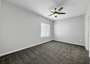 Thumbnail 31 of 57 - an empty living room with a ceiling fan and a window at Rialto Townhomes Apartments, Waukee, 50263