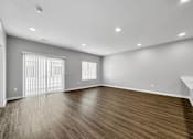 Thumbnail 35 of 57 - an empty living room with wood flooring and a window at Rialto Townhomes Apartments, Waukee