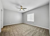 Thumbnail 23 of 57 - an empty living room with a ceiling fan and a window at Rialto Townhomes Apartments, Waukee, IA, 50263