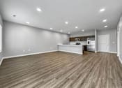 Thumbnail 33 of 57 - the living room and kitchen of a new home with wood flooring at Rialto Townhomes Apartments, Waukee, IA