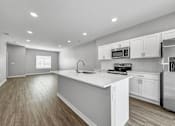Thumbnail 27 of 57 - a renovated kitchen with white cabinets and a white counter top at Rialto Townhomes Apartments, Waukee, Iowa