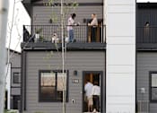 Thumbnail 54 of 57 - people standing on the balcony of a gray house at Rialto Townhomes Apartments, Waukee