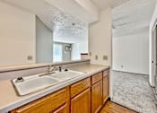 Thumbnail 7 of 33 - A kitchen with wooden cabinets and a white sink at Penbrooke Place Apartments, Sioux Falls