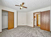 Thumbnail 10 of 33 - an empty living room with a ceiling fan and a door to a closet at Penbrooke Place Apartments, South Dakota, 57106