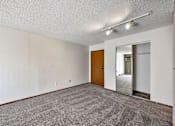 Thumbnail 3 of 33 - A room with a carpeted floor and a wooden door at Penbrooke Place Apartments, Sioux Falls, SD, 57106