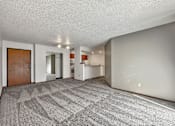 Thumbnail 6 of 33 - the living room and kitchen of an apartment with a carpeted floor at Penbrooke Place Apartments, South Dakota