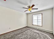 Thumbnail 11 of 33 - an empty room with a ceiling fan and a window at Penbrooke Place Apartments, Sioux Falls, SD