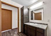 Thumbnail 17 of 33 - A bathroom with a sink, mirror, and toilet at Penbrooke Place Apartments, Sioux Falls, South Dakota