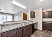Thumbnail 12 of 33 - a kitchen with granite counter tops and a stainless steel sink at Penbrooke Place Apartments, South Dakota