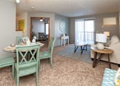 Thumbnail 21 of 33 - A living room with a dining table and chairs at Penbrooke Place Apartments, Sioux Falls, 57106